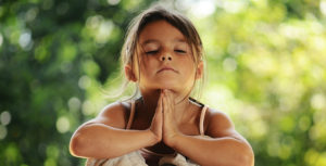 un enfant pratique la méditation de pleine conscience